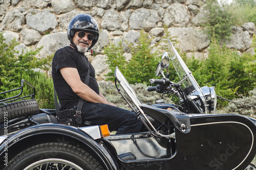 Fotografie Mature with sunglasses man on sidecar looking at camera