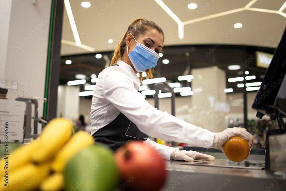 Female cashier in supermarket wearing hygienic protection mask and gloves  while working risky job because of corona virus pandemic. Stock 写真 | Adobe  Stock