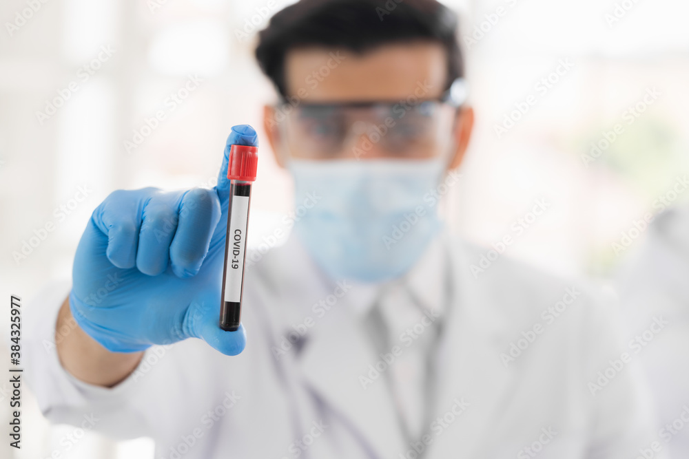 Researchers holding blood tube in life science laboratory. Male research scientist and supervisor preparing and analyzing microscope slides in research lab. Invention of the coronavirus vaccine