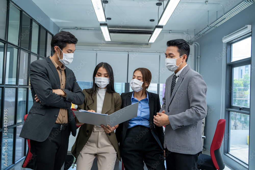 Group of businesspeople team in office wearing mask for protect corona virus disease working together during corona virus epidemic in office. Group of businesspeople team in office wearing mask for protect corona virus disease working together during corona virus epidemic in office.