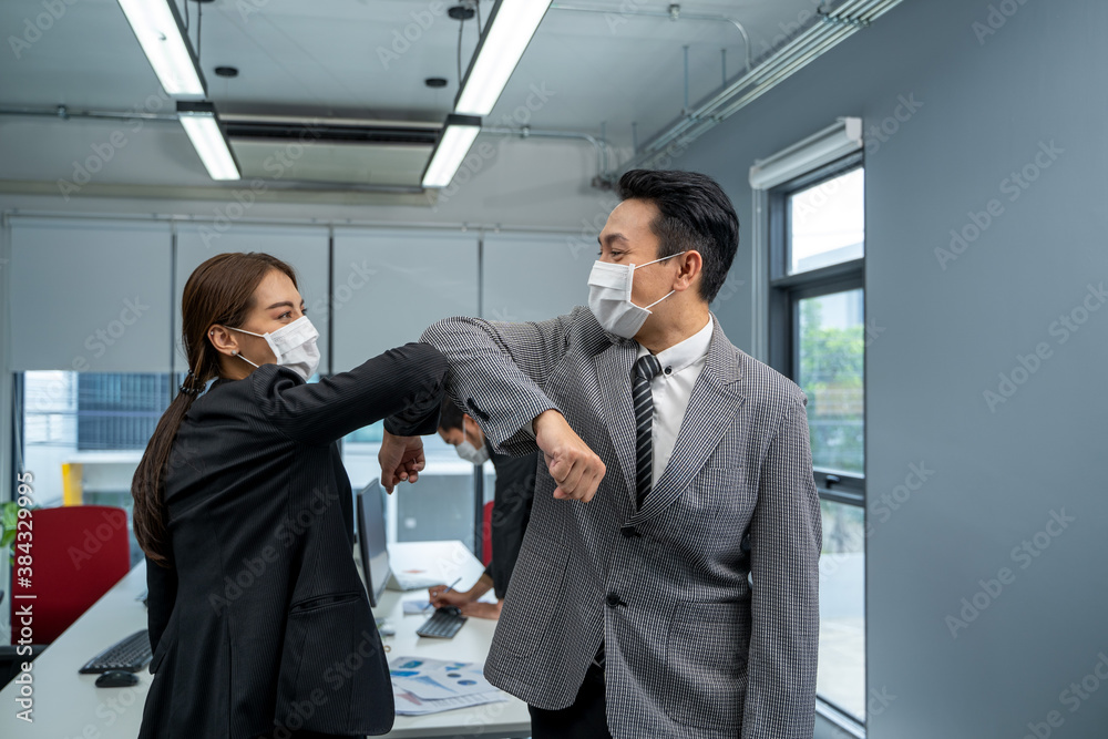 Businessman and businesswoman with medical mask in office after covid-19 quarantine and lockdown,Greetings in Covid-19 time. Businessman and businesswoman with medical mask in office after covid-19 quarantine and lockdown,Greetings in Covid-19 time.