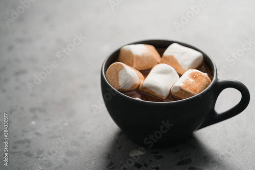 cup of hot chocolate with marshmallow on terrazzo background