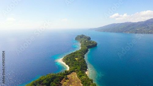Aerial view of Big Liguid Island with sand beach, palm trees by atoll with coral reef. Big Cruz Island, Philippines, Samal.