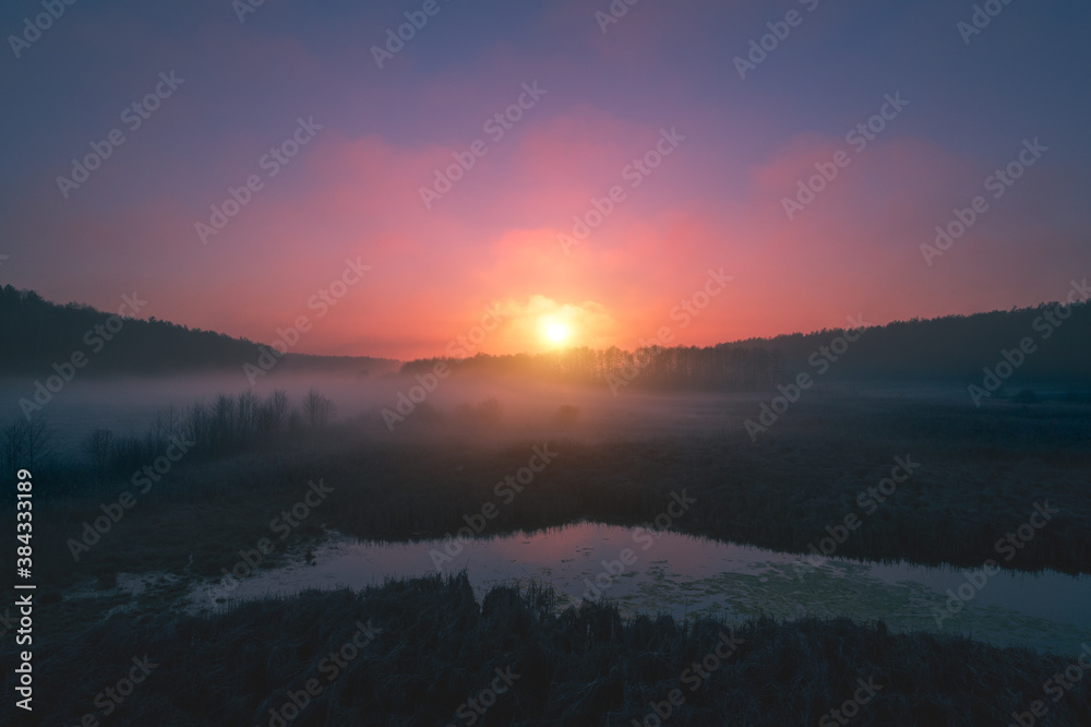 Magic sunrise over the lake. A serene lake in the early foggy morning. Nature landscape