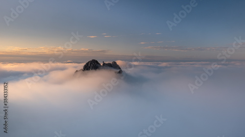 Fotografia tip of a mountain that appears in the clouds