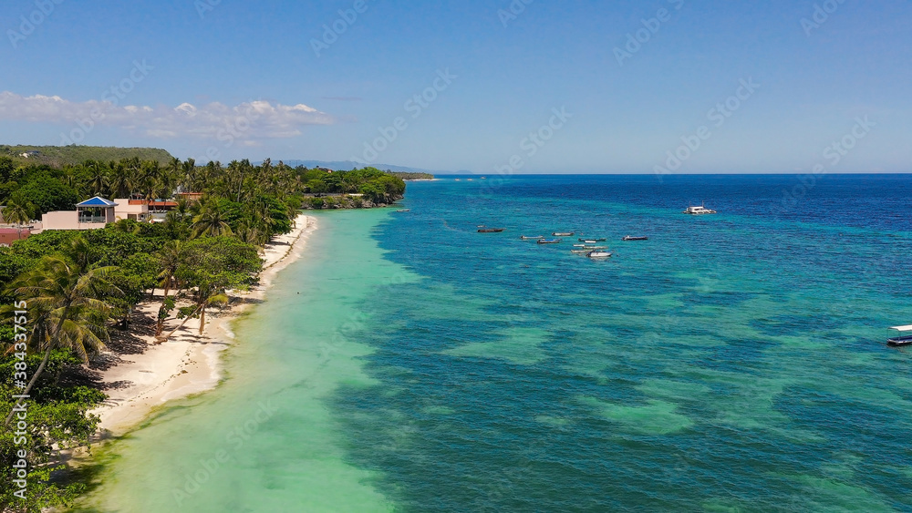 Beautiful tropical beach with white sand, palm trees, turquoise ocean. Alona beach, Panglao island, Bohol, Philippines.