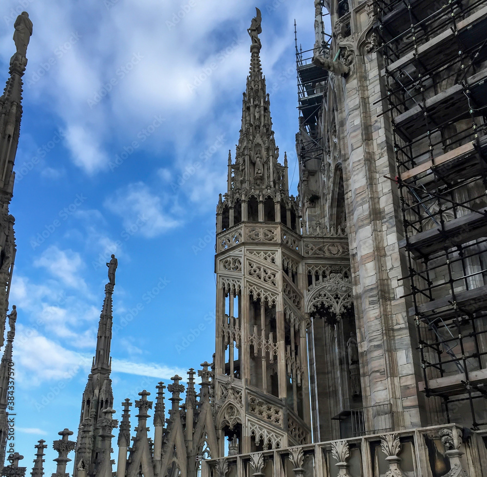 On top of the Milan Cathedral/church in Italy Europe.  With blue sky backdrop 