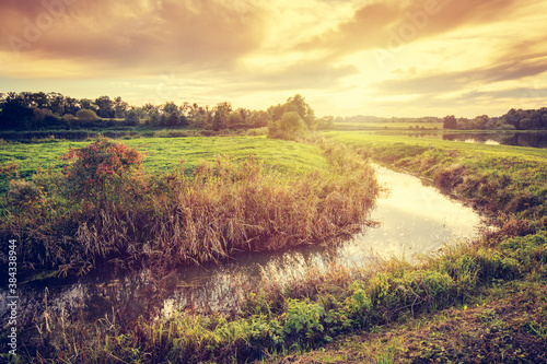 Fototapeta Naklejka Na Ścianę i Meble -  Countryside with small river at sunset.