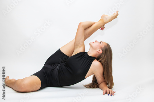 Beautiful girl hair engaged in yoga stretching fitness white background