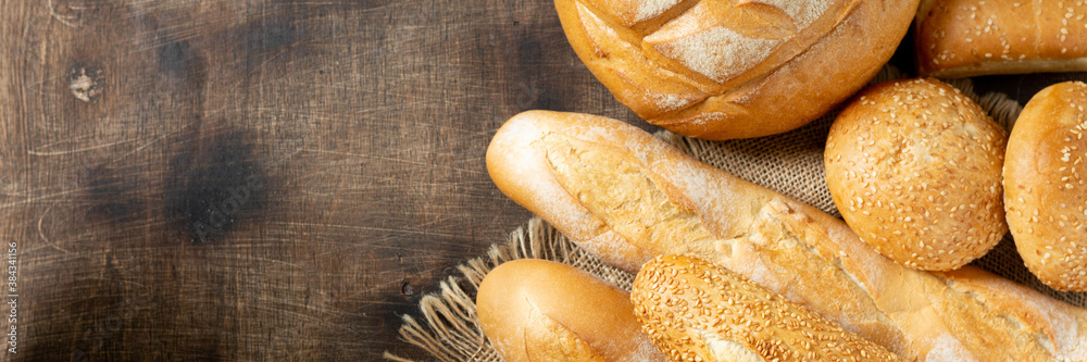 Baguettes. Baguettes on a brown wooden table. Homemade baguettes. French bread close-up. Top view with copyspace. Banner	
