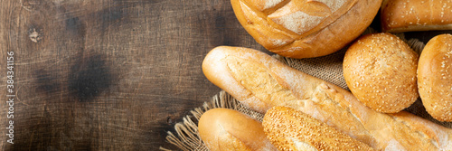 Obraz na płótnie Baguettes. Baguettes on a brown wooden table. Homemade baguettes. French bread close-up. Top view with copyspace. Banner
w salonie
