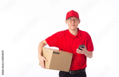 young Asian delivery man in red uniform, carry cardboard box in hands isolated on white background. © chee siong teh