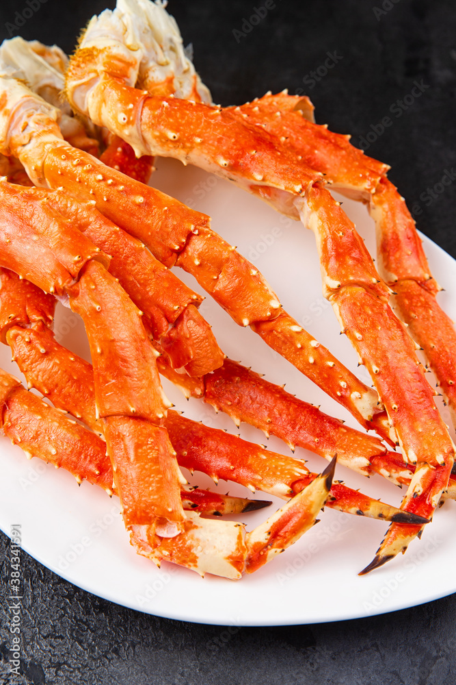 Crab legs in a plate on a dark background. Ready to eat. Crab legs in a plate on a dark background. Ready to eat.