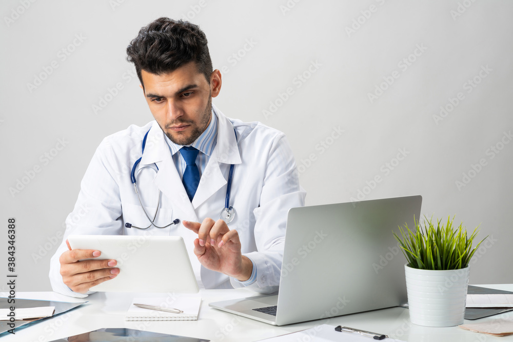 Young arab internist working with tablet computer Young arab internist working with tablet computer