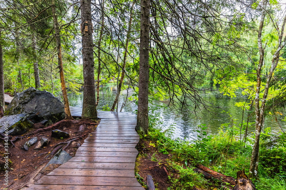 Obraz premium Park with the cascades of Akparhvenkoski waterfalls on the Tokhmayoki River, a popular tourist attraction situated near the settlement Ruskeala in Karelia, Russia