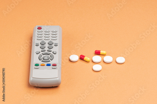 remote control and tablets on an orange background photo