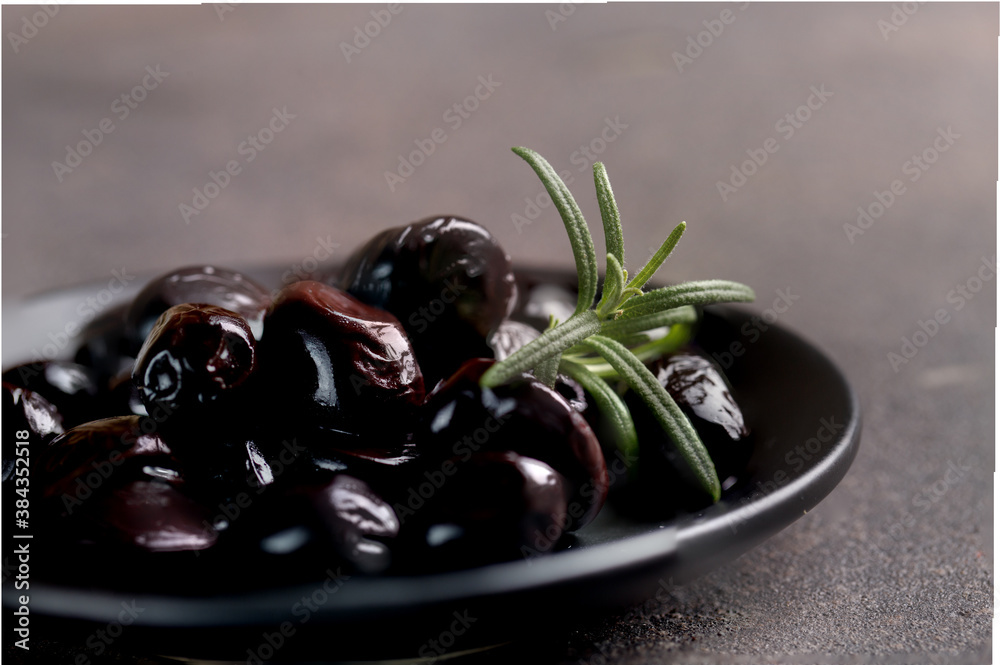 black olives on plate on dark background  