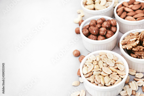 Colorful mix of various nuts: peanut and cashew, hazelnut and almond, pine nuts and walnut; healthy diet snack; selective focus, shallow DOF