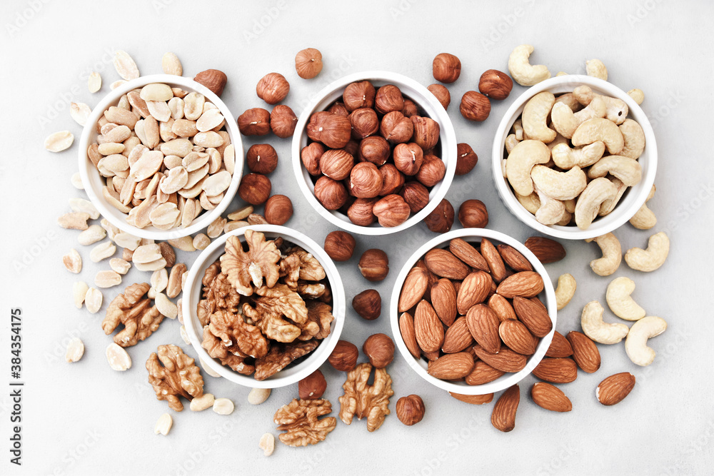 Colorful mix of various nuts: peanut and cashew, hazelnut and almond, pine nuts and walnut; healthy diet snack; vegan food background Colorful mix of various nuts: peanut and cashew, hazelnut and almond, pine nuts and walnut; healthy diet snack; vegan food background