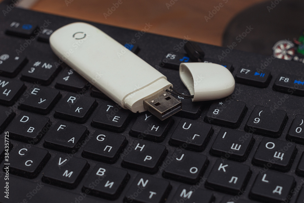 on the keyboard is a portable usb modem made of white plastic on the keyboard is a portable usb modem made of white plastic