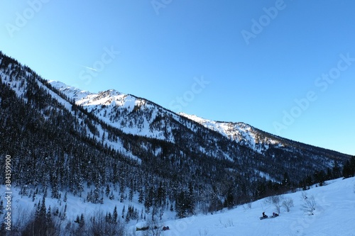 Winter mountain landscape at Baikal. Khamar-Daban ridge. Snow-capped peaks, chalets in the mountains. Winter forest.