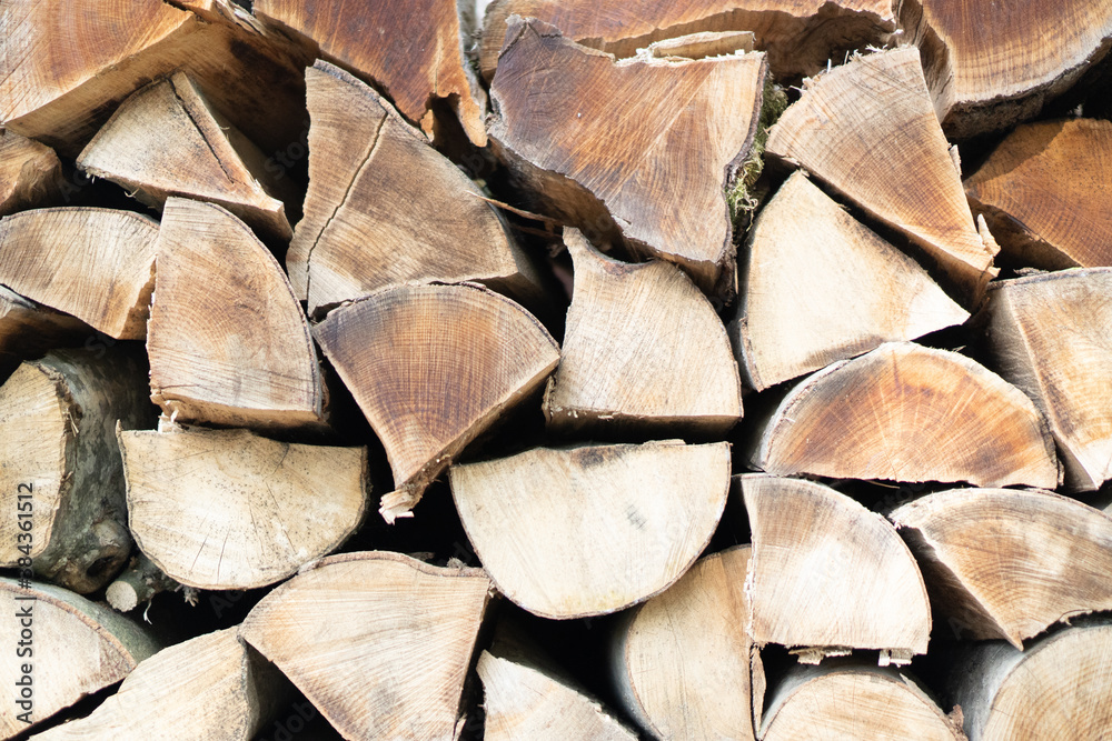 Fototapeta premium Dried firewood stacked under the wall. Background of dry chopped firewood logs in a pile. Close up texture