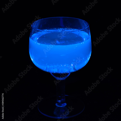 Glass of tonic glowing in UV