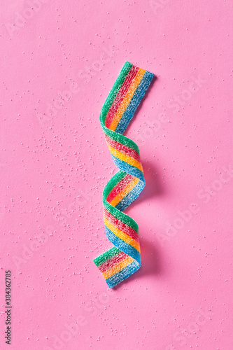 Colorful sugar candy ribbon on a pink background viewed from above. Top view.  © virtustudio