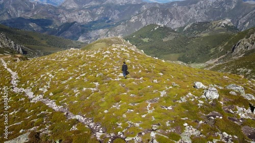 Aerial Circular view of a Male Alpinist and Climber in the Summit of a Mountain with impressive rocky views. Fitness, Sport and Healthy Life. Asturias, Spain