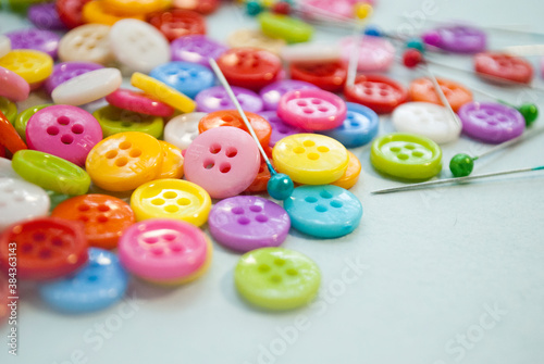 Bright buttons, background. Needlework / handicraft. Buttons and sewing pins, selective background.