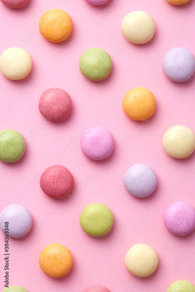 Colorful round candy sweets pattern on a pink background viewed from above. Top view