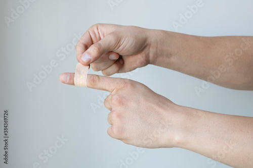 hand putting Adhesive Bandage. band-aid on a cut. isolated on white