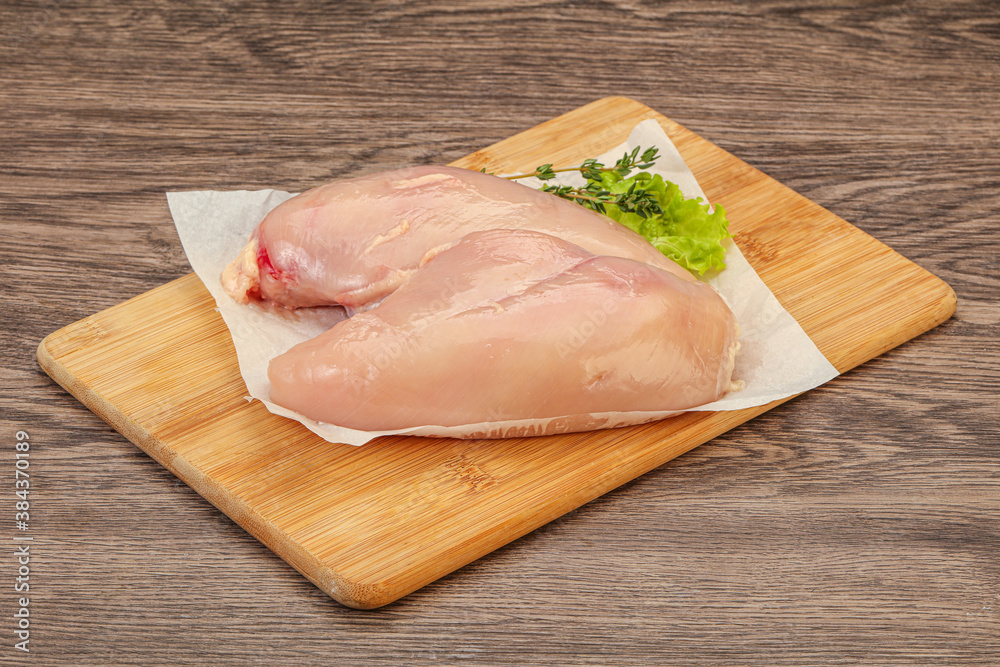 Raw chicken breast over board