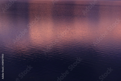 夕暮れを写した紫とオレンジの水面