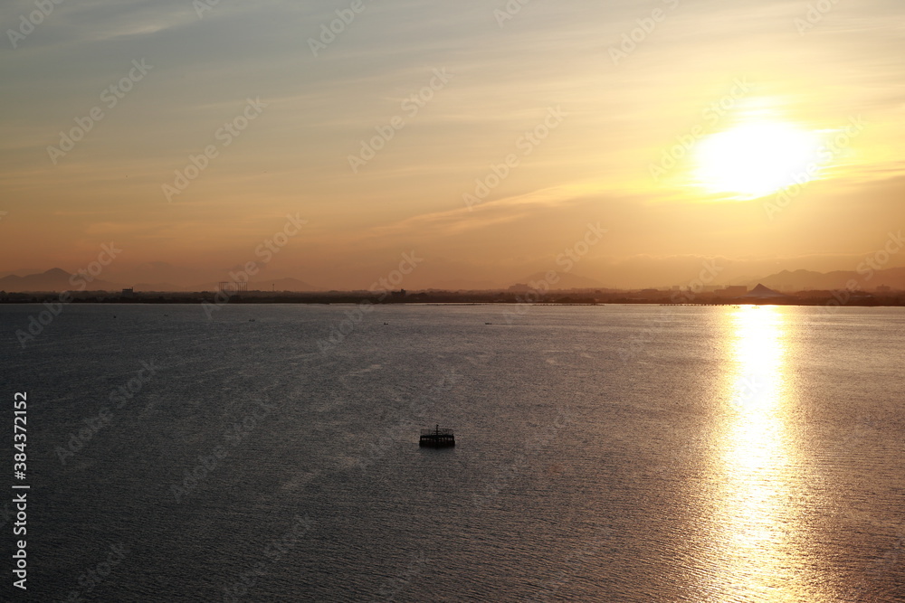 昇る朝日が湖に反射して綺麗な写真
