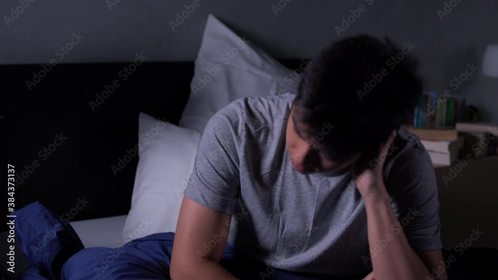 Depressed young Asian man cannot sleep from insomnia. Depressed man suffering from insomnia lying in bed. Depressed young Asian man cannot sleep from insomnia. Depressed man suffering from insomnia lying in bed.