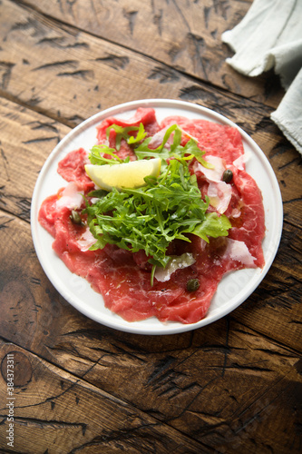 Traditional beef carpaccio with parmesan cheese and arugula