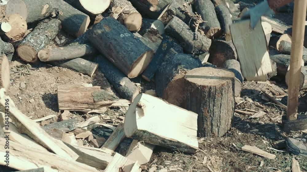 Men chopping firewood for heating at home. Men chopping firewood for heating at home.
