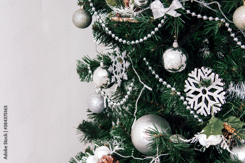 New Year's Space for text. Christmas green tree decorated with white and silver balls and toys