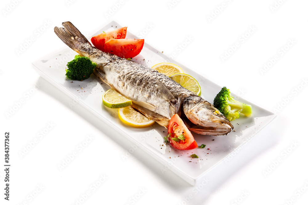 Fish dish - roasted trout with vegetables on white background
Fish dish - roasted trout with vegetables on white background