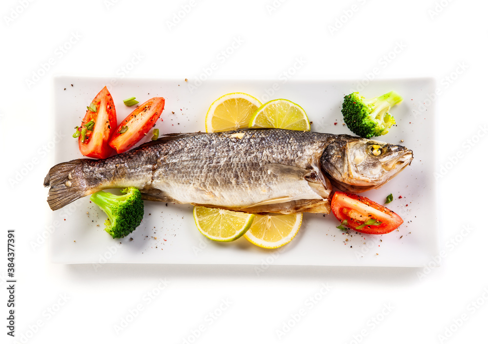 Fish dish - roasted trout with vegetables on white background
Fish dish - roasted trout with vegetables on white background