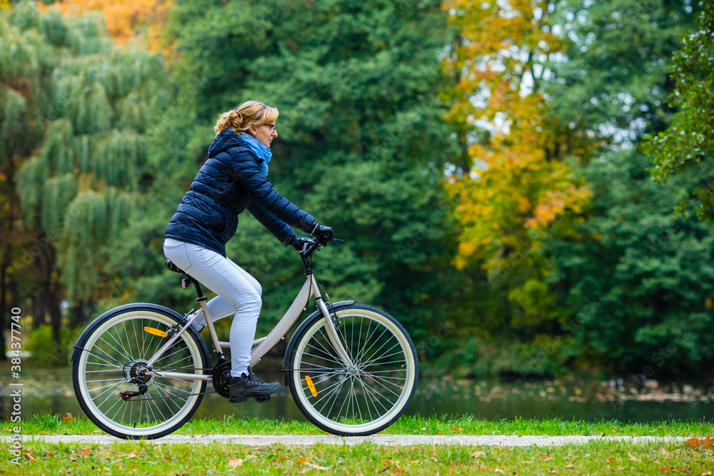 Urban biking - woman riding bicycle in city park
