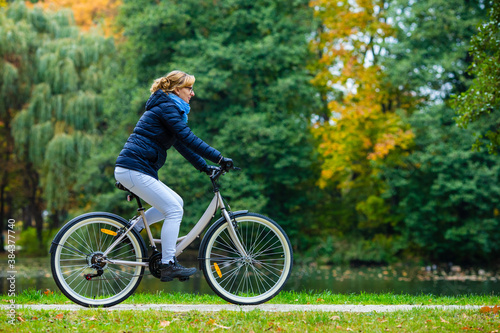 Urban biking - woman riding bicycle in city park 