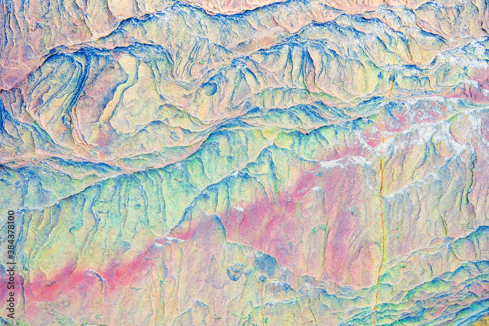 Colourful mosaics or rocks - layered sedimentary minerals exposed by sea - textured background Colourful mosaics or rocks - layered sedimentary minerals exposed by sea - textured background