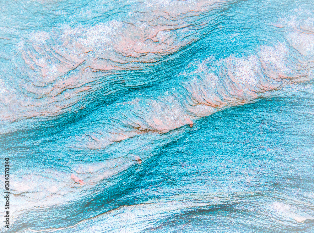Obraz premium Abstract blue, gray, orange and green background - layers of rocks exposed by sea in Northumberland