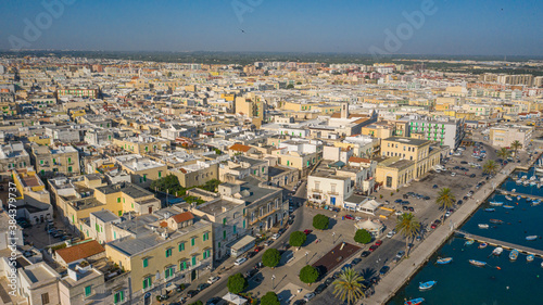 Beautiful panoramic aerial view photo from flying drone on Molfetta waterfront and the old town from a great height.Port with ships and yachtsand the Molfetta new city at sunrise.Apulia,Italy (Series) photo