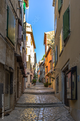 Morning walk in empty Croatian city of Rovinj.Picturesque narrow cobblestone streets colorful facades small shops beautiful European cityscape.Summer holiday background.Real estate concept.