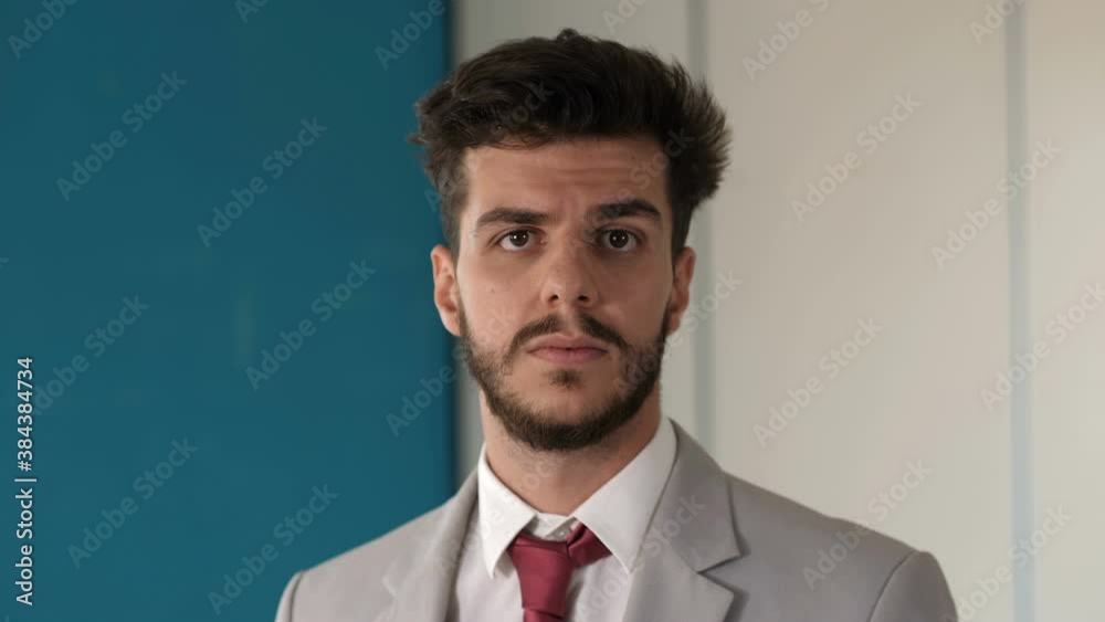 young focused businessman looking at camera lost in his thoughts young focused businessman looking at camera lost in his thoughts
