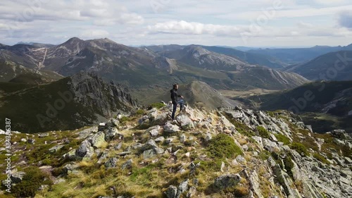 Aerial Circular view of a Male Alpinist and Climber in the Summit of a Mountain with impressive rocky views. Fitness, Sport and Healthy Life. Asturias, Spain