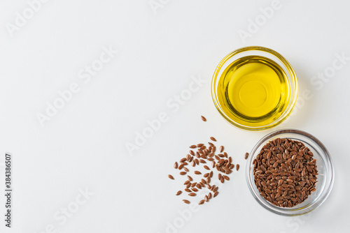 Flaxseed oil flaxseeds in glass containers on a white background with copy space  top view